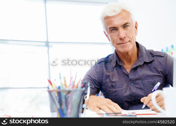 Handsome businessman in office. Handsome businessman in casual wear working in office