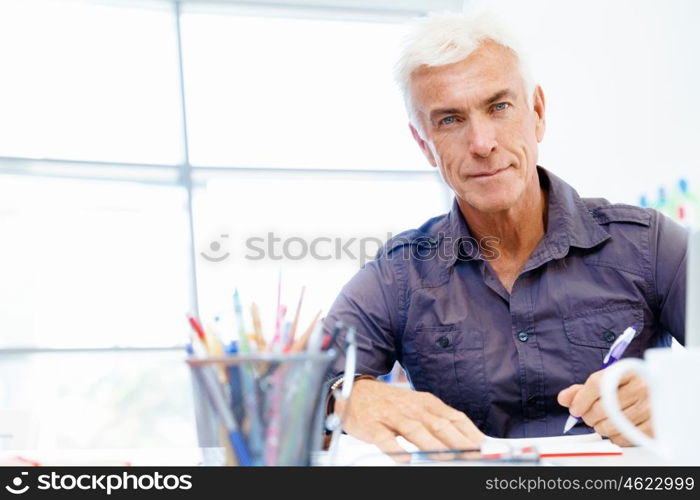 Handsome businessman in office. Handsome businessman in casual wear working in office