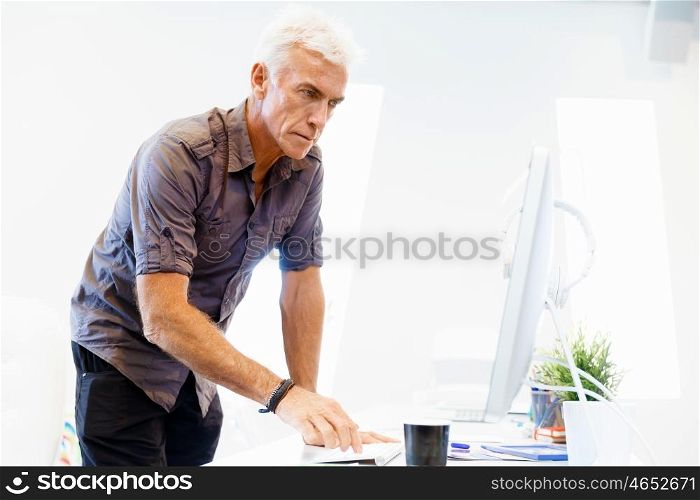 Handsome businessman in office. Handsome businessman in casual wear working in office