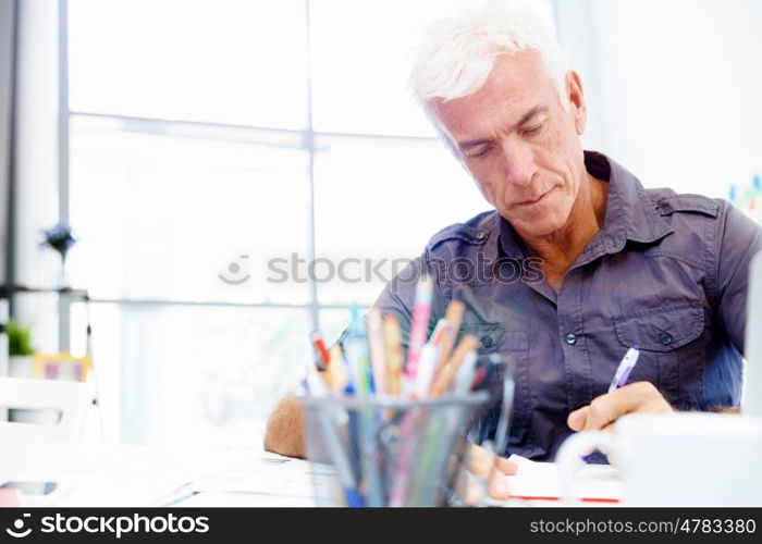 Handsome businessman in office. Handsome businessman in casual wear working in office