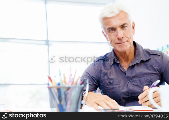 Handsome businessman in office. Handsome businessman in casual wear working in office