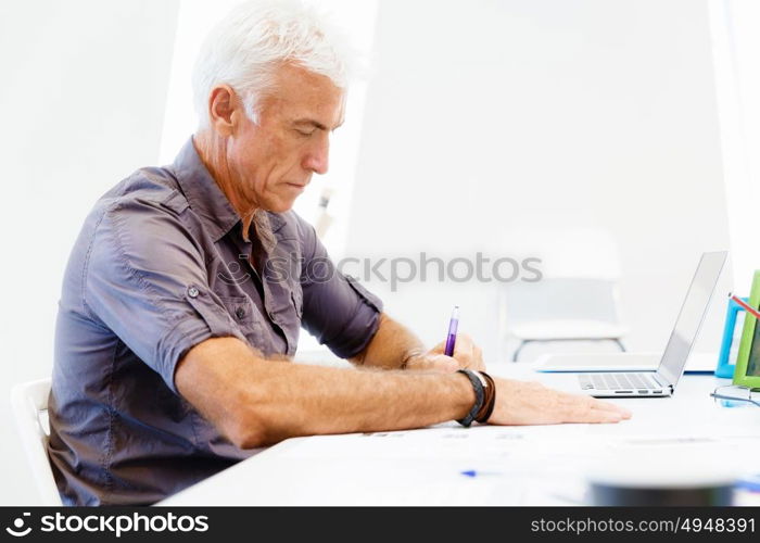 Handsome businessman in office. Handsome businessman in casual wear working in office