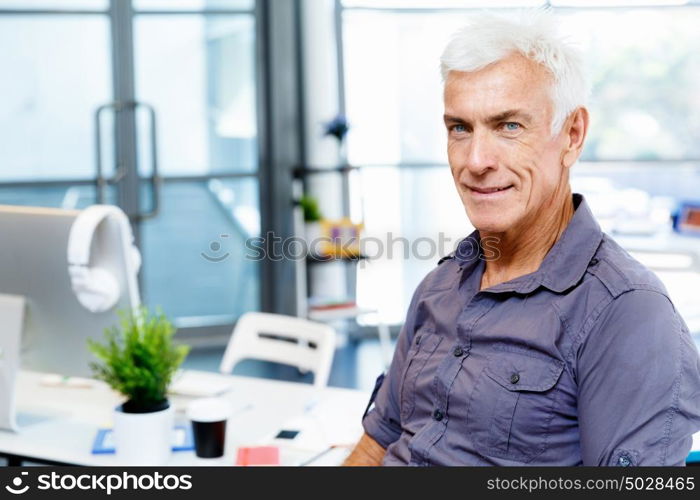 Handsome businessman in office. Handsome businessman in casual wear working in office