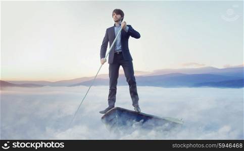 Handsome businessman rowing in the boat
