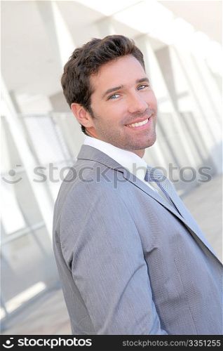 Handsome businessman standing in front of building