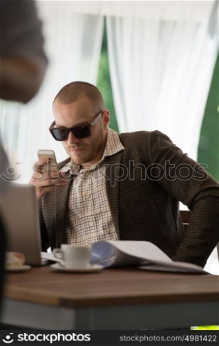 Handsome businessman talking on the phone in a cafe