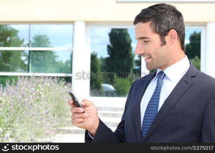 Handsome businessman texting on a mobile phone