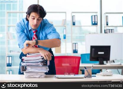 Handsome businessman unhappy with excessive work in the office  . Handsome businessman unhappy with excessive work in the office 