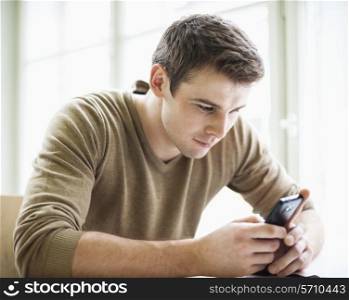 Handsome businessman using cell phone in office