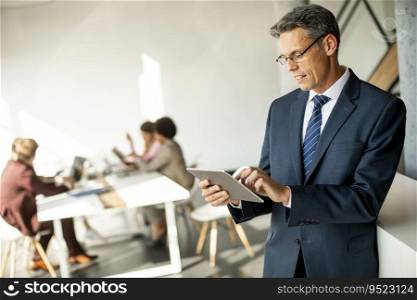 Handsome businessman using his digital tablet in the office