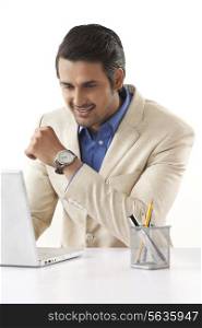 Handsome businessman using laptop at office desk