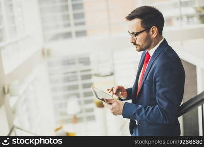 Handsome businessman using tablet in office