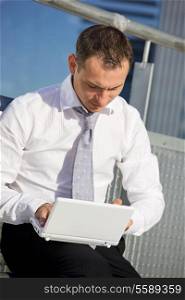 handsome businessman with laptop computer in the city