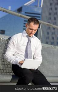 handsome businessman with laptop computer in the city