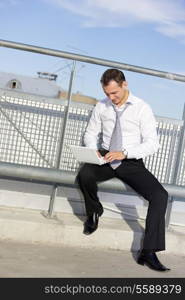 handsome businessman with laptop computer in the city