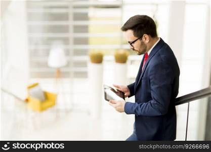 Handsome businessman with tablet in office