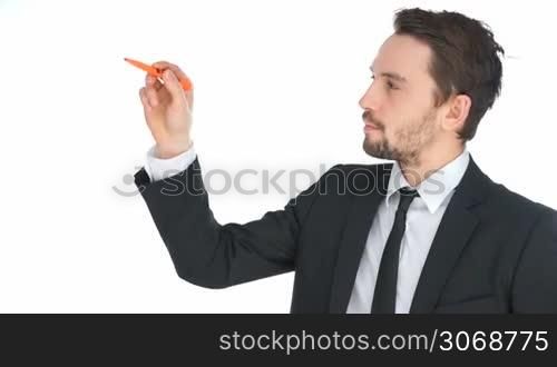 Handsome businessman writing on a virtual screen with a marker pen as he does a presentation, isolated on white