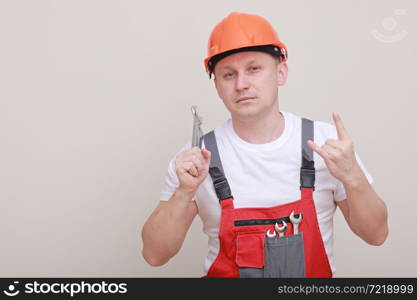 Handsome car mechanic male worker holding equipment tool, wrench standing in red uniform, safety helmet on white background. Handsome car mechanic male worker holding equipment tool, wrench standing in red uniform, safety helmet on white background.