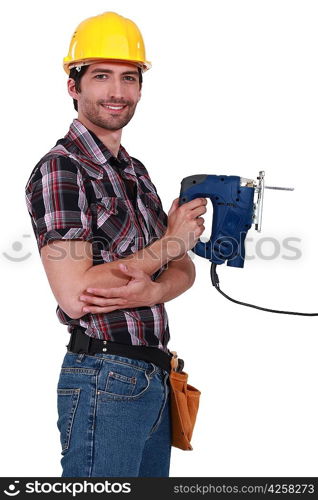 Handsome carpenter holding electric saw