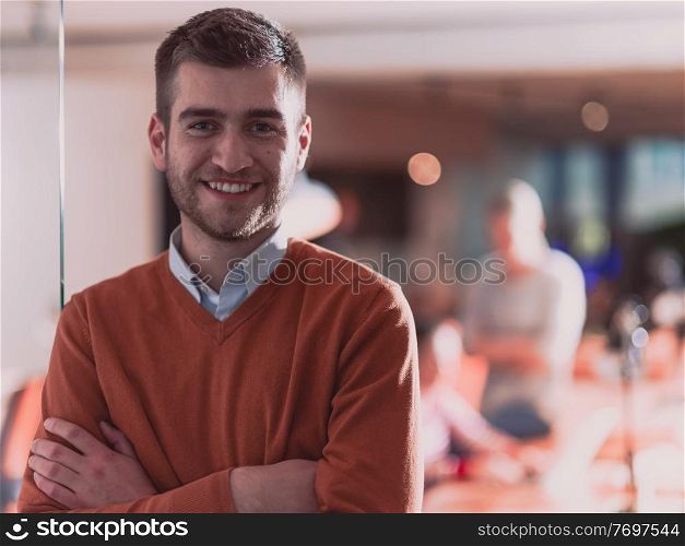 Handsome casual businessman standing confident in the office. Disabled businesswoman in wheelchair working together with the team in the background. High quality photo. Follow focus. . Handsome young business man standing confident in the office in front of his team