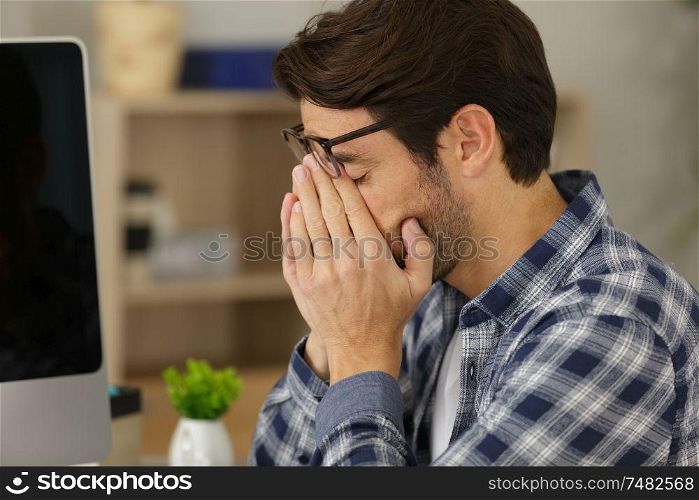 handsome casual man tired rubbing eyes