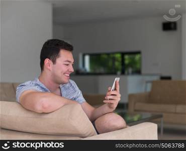 Handsome casual young man using a mobile phone at luxurious home