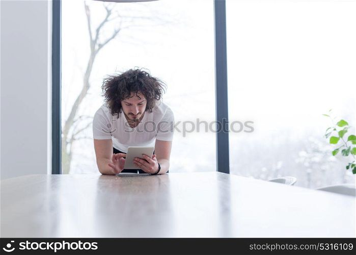 Handsome casual young man using a tablet at luxurious home