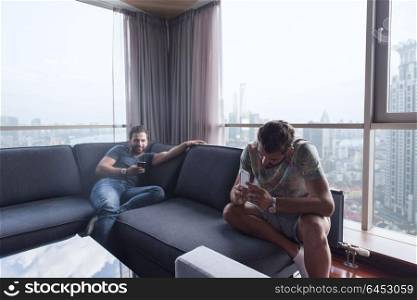 Handsome casual young men using a mobile phones near the window at home