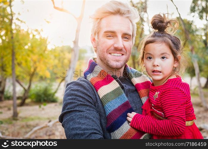 Handsome Caucasian Young Man with Mixed Race Baby Girl Outdoors.