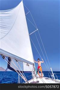 Handsome cheerful man having fun on beautiful luxury sailboat, spending summer vacation in sea cruise, enjoying freedom and recreation
