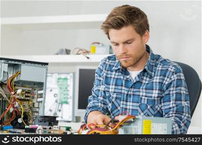 handsome computer engineer repairing a faulty pc