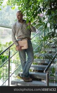 Handsome confident businessman portrait standing on stairs and holding documents