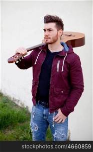 Handsome cool man carrying a guitar on his shoulders