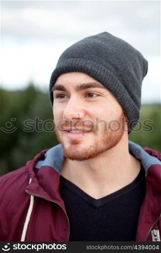 Handsome cool man with cap wool smiling outside
