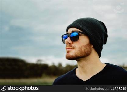 Handsome cool young man with sunglasses and cap wool