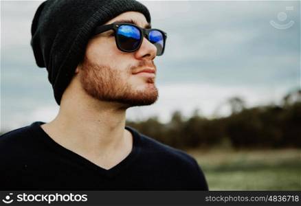 Handsome cool young man with sunglasses and cap wool