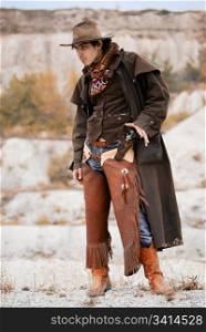 handsome cowboy in specific clothing with weapon. outdoor shot