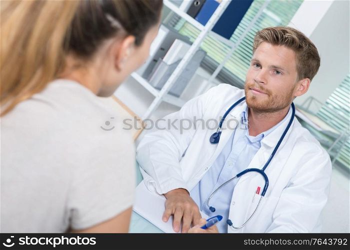 handsome doctor during consultation with female patient