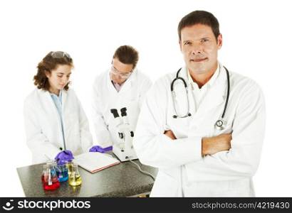Handsome doctor in the medical lab, with scientists working in background. Isolated over white.