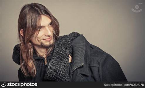 Handsome fashion man portrait wearing black coat.. Portrait of handsome fashionable man wearing black sweater and scarf holding coat. Young guy posing in studio. Winter or autumn fashion. Instagram filter.