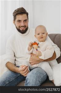 handsome father posing couch with baby