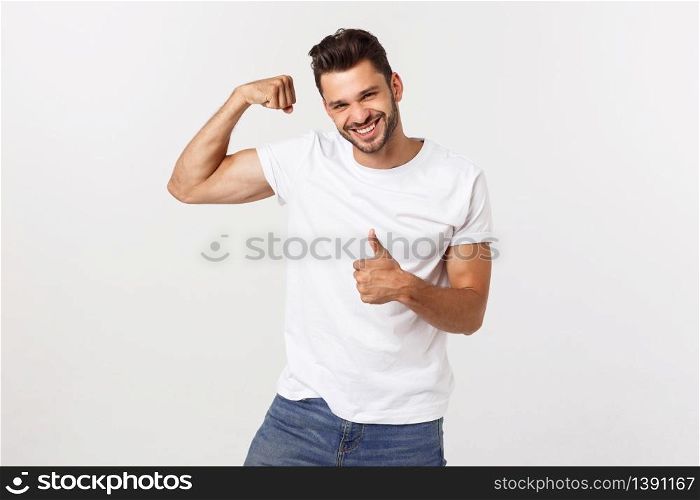 Handsome fit young funny bearded man pointing to his bicep and smiling on white background.. Handsome fit young funny bearded man pointing to his bicep and smiling on white background