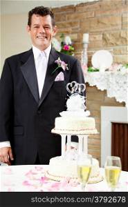 Handsome groom standing beside the wedding cake at his gay wedding, waiting for his husband.