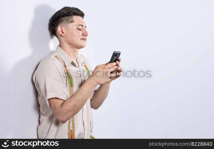 Handsome guy happy with his cell phone on isolated backgrounds, young latin man happy with his cell phone isolated, man on white background texting with his cell phone