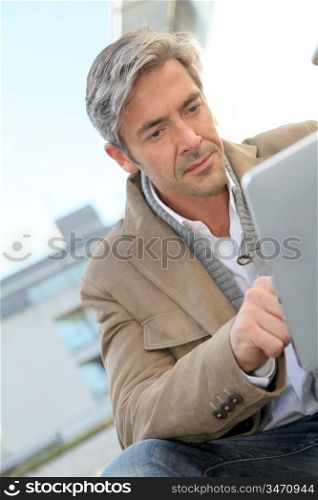 Handsome guy in town using electronic tablet