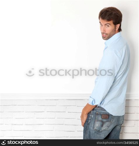 Handsome guy leaning on white wall