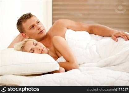 Handsome guy lost in thoughts as woman takes sound sleep