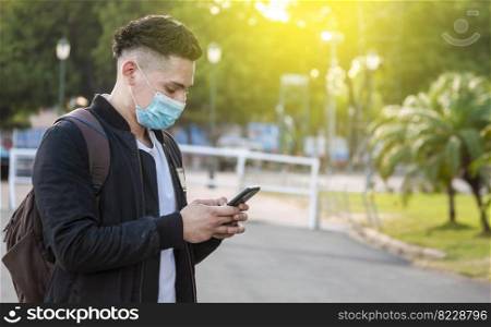 Handsome guy texting with his phone, Handsome young man in face mask texting with his phone, Handsome man texting on his phone