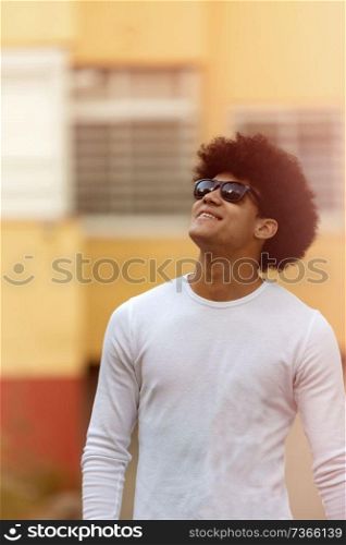 Handsome guy with afro hairstyle and sunglasses on the street