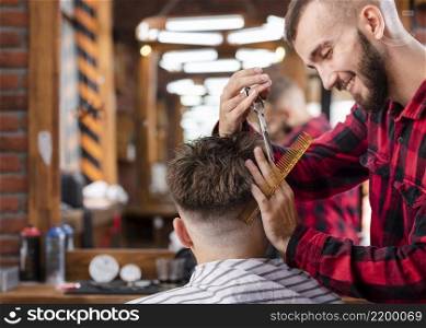 handsome hairdresser making hipster haircut